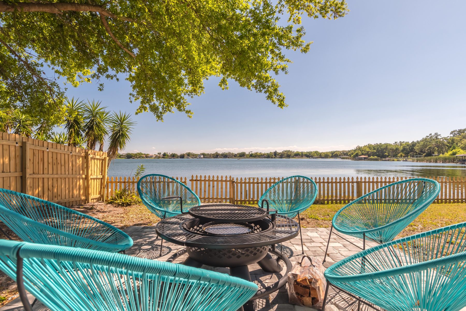 Lakeside fire pit with teal chairs and Lake Holden views