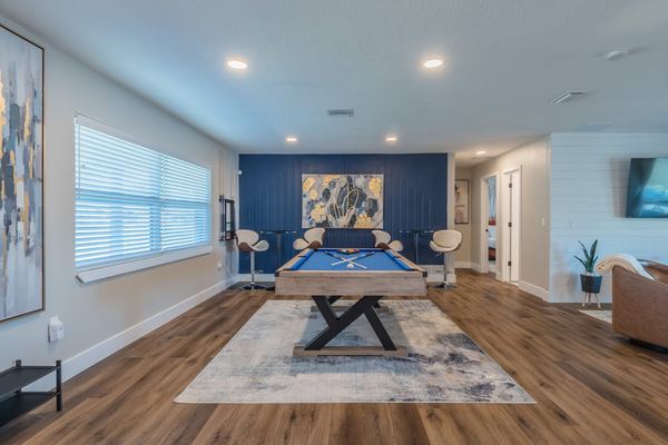 Game room with pool table and navy accent wall