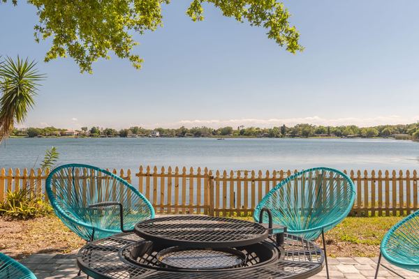 Teal Acapulco chairs at lakeside fire pit